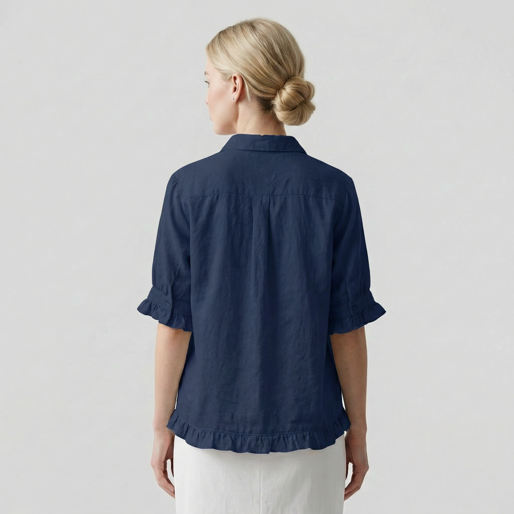 Person wearing a navy blue shirt with rolled-up sleeves on a light gray background