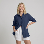 Woman wearing a navy blue shirt and white shorts on a plain background