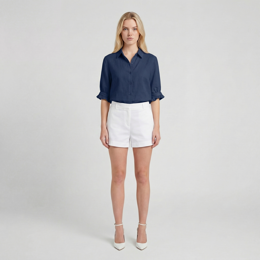 Woman wearing a navy shirt and white shorts on a plain background