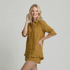Woman wearing a mustard yellow outfit with ruffled sleeves and hem on a plain background