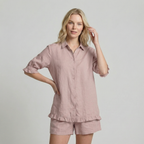 Woman wearing a pink blouse set against a plain background