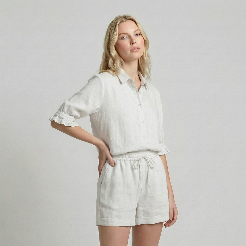 Woman wearing a white shirt and shorts on a plain background