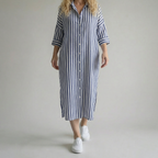 Person wearing a blue and white striped dress on a plain background