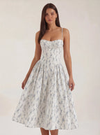 Woman wearing a floral dress against a plain background