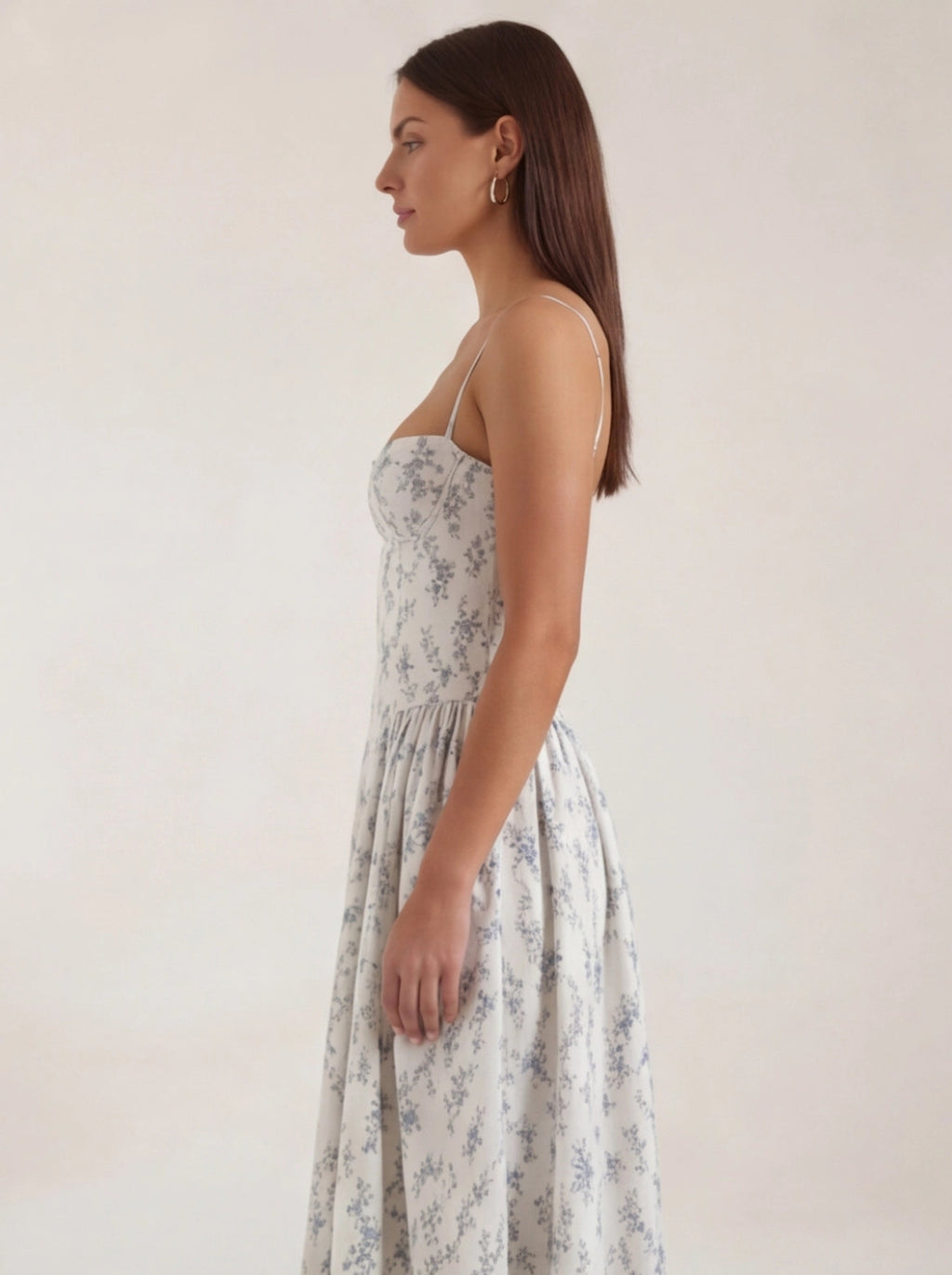 Woman wearing a floral dress against a plain background