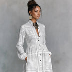 Woman wearing a white geometric patterned dress against a gray background